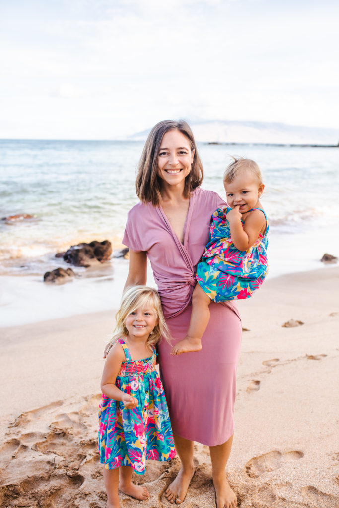 Pediatric dentist Dr. Erica Hollander smiling on a beach with two children